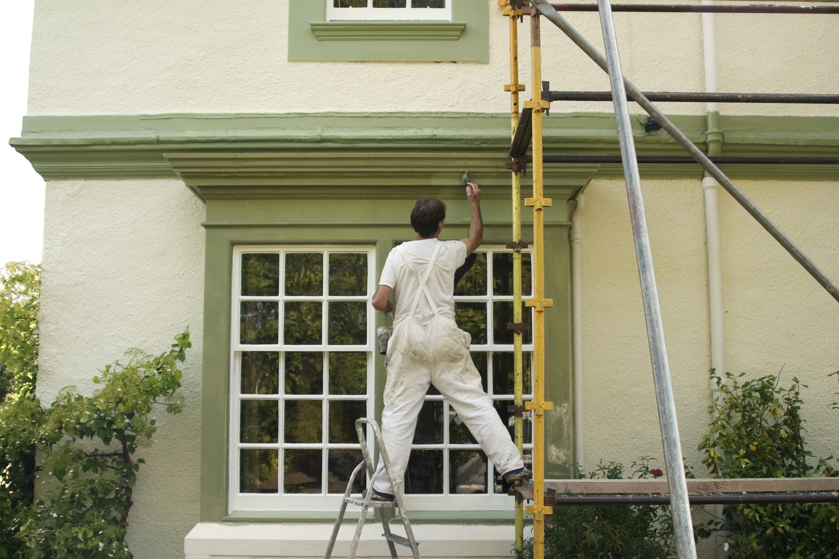 Painter decorating a house exterior.